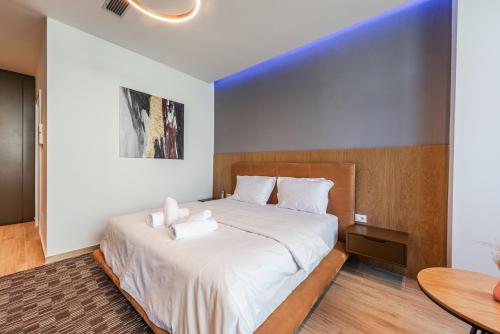a bedroom with a large bed with white sheets at Marina Luxury Suites by PS in Durrës