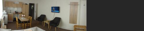 a kitchen and a living room with a table and chairs at Penzion U Hradeb in Znojmo