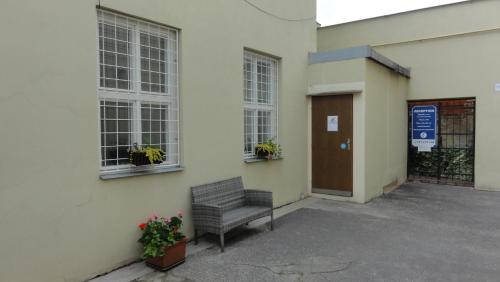 a bench sitting outside of a building with windows at Penzion U Hradeb in Znojmo