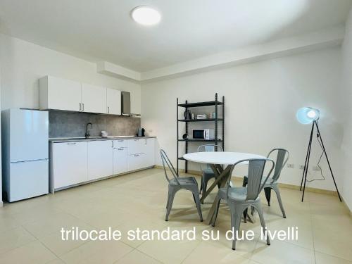a kitchen and dining room with a table and chairs at Appartamenti Shardana in Villasimius