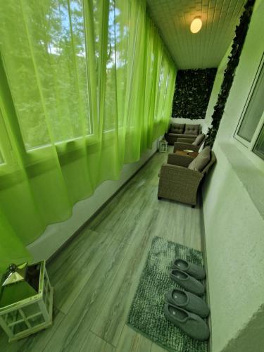 a living room with green curtains and a couch and chairs at Apartament Luna in Reghin