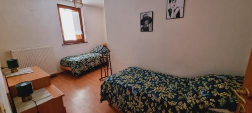 een slaapkamer met een bed, een stoel en een raam bij Stefy House in Pontebba