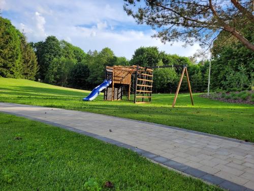 a playground with a slide in a park at Trzy Fale in Dąbrówno