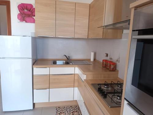 una piccola cucina con frigorifero bianco e lavandino di Vacanze Sicilia a Trappeto