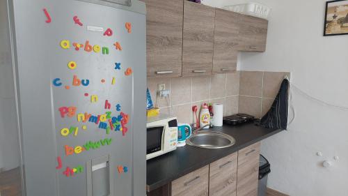 a kitchen with a refrigerator with alphabet magnets on it at Penzion Hřensko in Hřensko