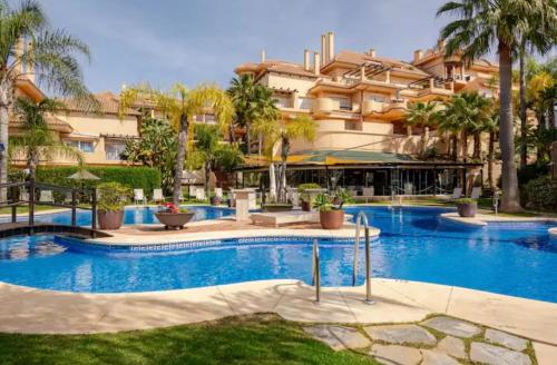 ein Schwimmbad vor einem großen Gebäude in der Unterkunft Luxury 2 bedroom apartment, close to the sea and the golf course, Aloha Hills Club Property in Marbella