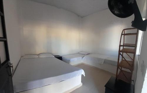 a white room with two beds and a ladder at CASA QUINTA VILLA CECILIA CARMEN DE APICALA in Carmen de Apicalá