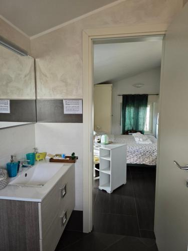 a bathroom with a sink and a room with a bed at Villa La Baia a pochi passi dal lago in San Felice del Benaco