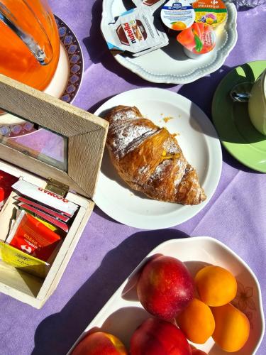 a table topped with plates of food with bread and fruit at Villa La Baia a pochi passi dal lago in San Felice del Benaco