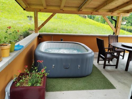 einen Whirlpool auf einer Terrasse mit einem Tisch und Stühlen in der Unterkunft Holiday House Provance in Brod na Kupi