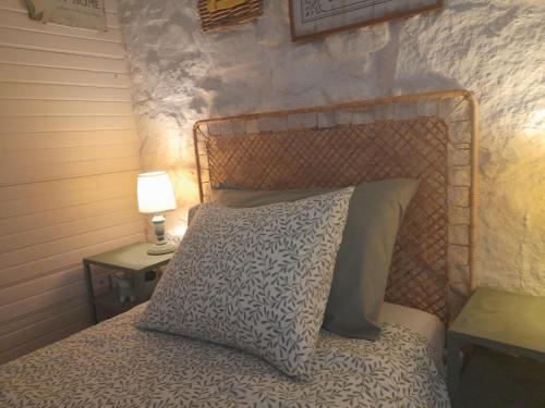 ein Bett mit einem Kissen und einer Lampe auf einem Beistelltisch in der Unterkunft Quinta da Maínha - Charming Houses in Braga