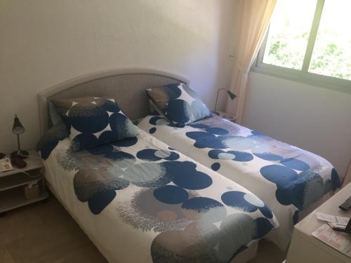 une chambre avec un lit avec une couette bleue et blanche dans l'établissement Cannes 2 pièces - Parking, à Cannes