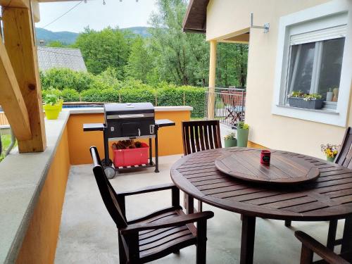 einen Grill auf einer Terrasse mit einem Tisch und Stühlen in der Unterkunft Holiday House Provance in Brod na Kupi