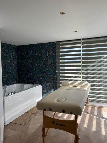 Cette chambre dispose d'une baignoire et d'un lit. dans l'établissement Appartement ESCAPADE BIEN ETRE & DECONNEXION, à Roumens