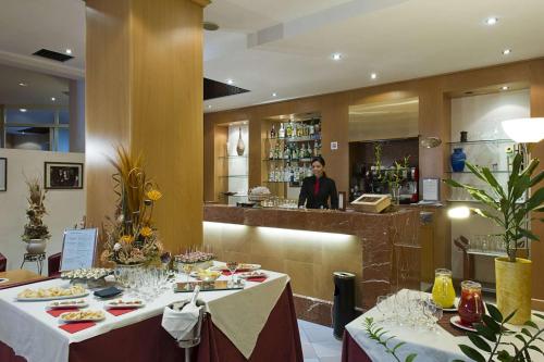 a woman standing behind a counter in a restaurant at Classic Hotel Tulipano in Terni