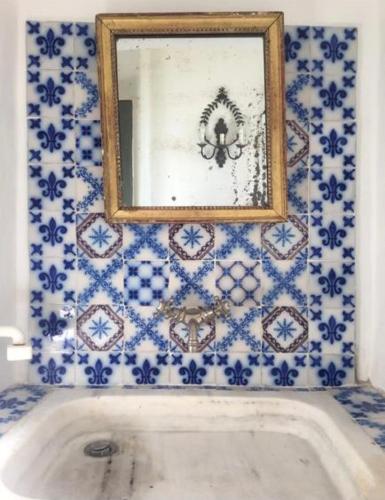 La salle de bains est pourvue d'un miroir et d'une baignoire. dans l'établissement Air-conditioned authentic village house with sea view, terraces and swimming pool, à Monticello