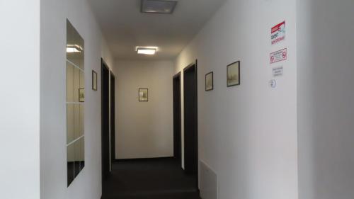 a hallway with white walls and black doors at willa wena in Krynica Zdrój
