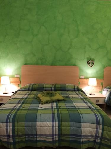 a bedroom with a bed with a green wall at Green Quiet Affittacamere in Pignone