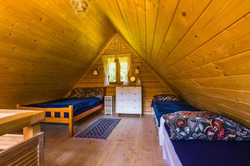 1 dormitorio en una cabaña de madera con 2 camas en Smerekowiec domek w lesie, en Smerekowiec