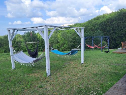 a group of hammocks in a field at Jaśkowe Wzgórze domki na wynajem Szymbark, balia, Domek nr 2 i 3 in Szymbark