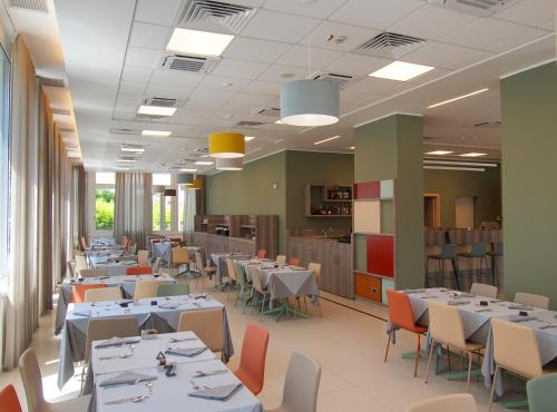 uma sala de jantar com mesas e cadeiras e uma cafetaria em Tower Hotel em Busto Arsizio