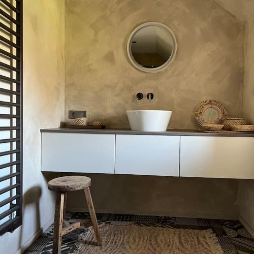 a bathroom with a sink and a stool and a mirror at Le lodge Cotentin - Maison de charme vue mer in Éculleville