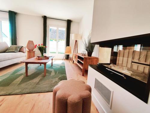 un salon avec un canapé et une table dans l'établissement Les Embruns Charmante maison A 50m de la plage, à Colleville-Montgomery