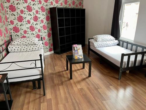 une chambre avec deux lits et une table dans l'établissement Entire PinkApt - Free parking - Up to 4 guests - 3 beds - Close to city centre, à Belfast