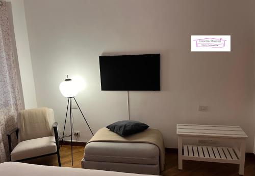 a living room with a couch and a tv on the wall at Casetta Mazzini in Rapallo