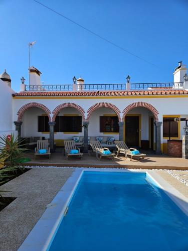 a villa with a swimming pool in front of a building at Ribeiros do Alqueva in Mourão