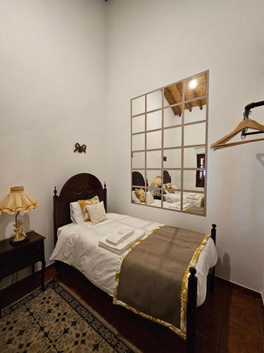 a bedroom with a bed and a mirror on the wall at Ribeiros do Alqueva in Mourão