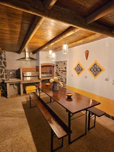 a dining room with a wooden table and a bench at Ribeiros do Alqueva in Mourão
