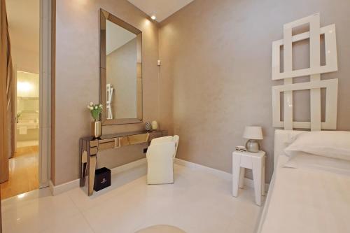 a white bedroom with a sink and a mirror at Domus Aurea Luxury Suites in Rome