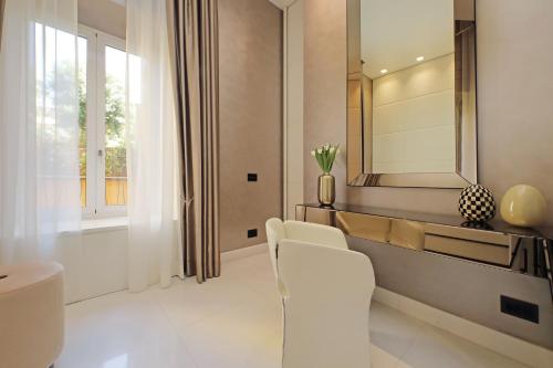 a bathroom with a mirror and a white chair at Domus Aurea Luxury Suites in Rome