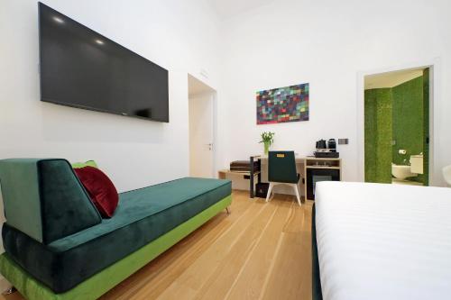 a bedroom with a couch and a desk with a television at Domus Aurea Luxury Suites in Rome