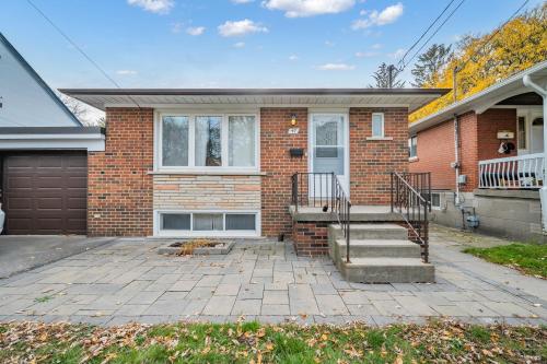 a brick house with a porch and a driveway at Luxury Renovated House in Prime Location with Parking in Toronto