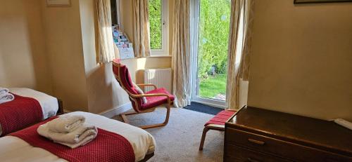 - une chambre avec deux lits, une chaise et une fenêtre dans l'établissement Mandalay Holiday Home, à Amesbury