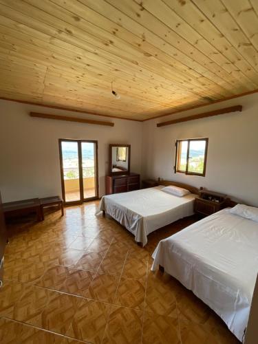 two beds in a large room with wooden ceilings at Athens apartment Greece in Sarandë