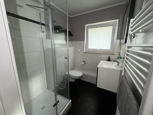 uma casa de banho com um chuveiro, um WC e um lavatório. em Ferienwohnung vor den Toren Berlins em Heidesee