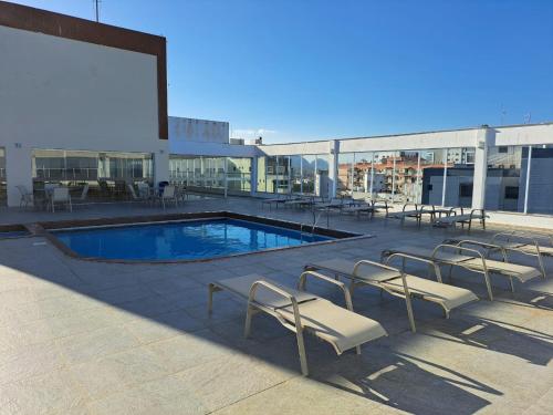 - une piscine sur le toit d'un immeuble avec des chaises longues dans l'établissement Areia Preta, à Guarapari