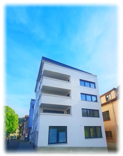 a white building with balconies on a city street at Ferienwohnung an der Allee in Waldkirch