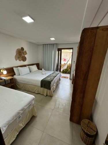 Habitación de hotel con 2 camas y ventana en Pousada Corais do Bitingui en Japaratinga