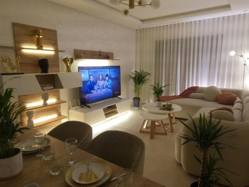 a living room with a couch and a tv at Appartement charmant au parc de Mohammedia, à seulement 2 pas de la plage in Mohammedia