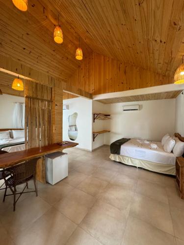 a bedroom with a bed and a wooden ceiling at Pousada Corais do Bitingui in Japaratinga
