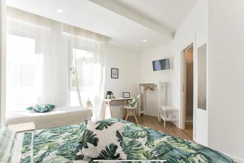 una camera bianca con un letto e una finestra di Catalogna10 Rooms ad Alghero