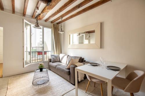 un salon avec un canapé et une table dans l'établissement Geranimus 36B : Hearth of Paris, à Paris