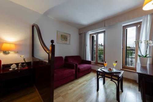 a living room with a red couch and a table at Hotel Hannover in Grado