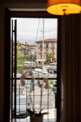 a window with a view of a marina with boats at Hotel Hannover in Grado
