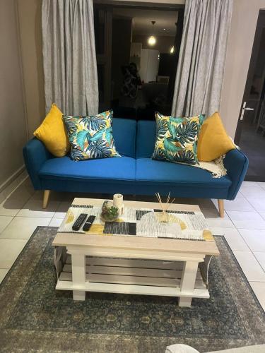 a blue couch in a living room with a coffee table at Su Casa Port Alfred in Port Alfred