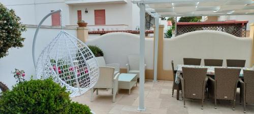 een patio met een tafel en stoelen en een parasol bij Sofia in Castro di Lecce